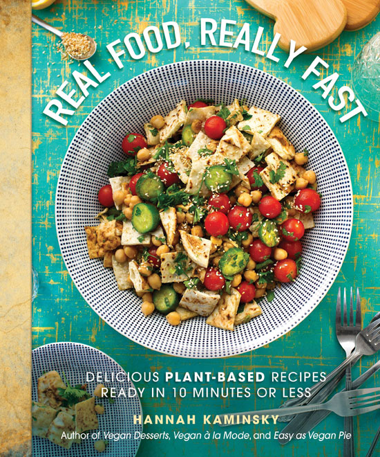Cookbook cover with a photo of a meal prepared on a table decorated with cutlery and other things. Text in the foreground says "Real Food, Really Fast. Delicious plant-based recipes ready in 10 minutes or less. Hannah Kaminsky. Author of Vegan Desserts, Vegan a la Mode, and Easy as Vegan Pie."