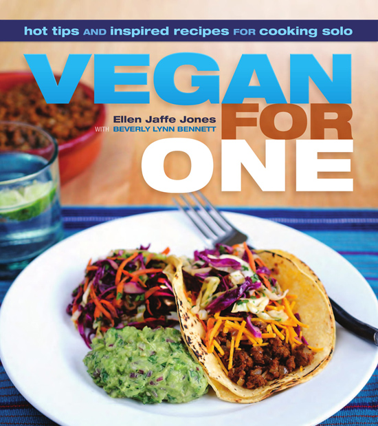 Image contains a photo of a single taco, guacamole, and a small salad on a plate. In the background, there is a glass of water with lime and a bowl of veggie ground beef. Text above the photo says "Hot tips and inspired recipes for cooking solo. Vegan For One. Ellen Jaffe Jones with Beverly Lynn Bennett."
