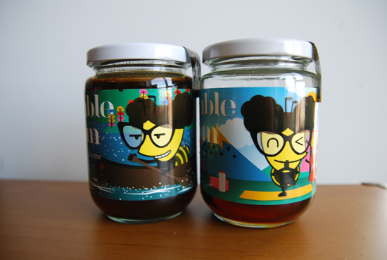 Photo of two jars of Bumble Bloom, a vegan honey alternative, sitting on top of a wooden surface with a white background