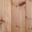 Image contains vertical wood panelling with a number of darker brown knots scattered throughout each panel.