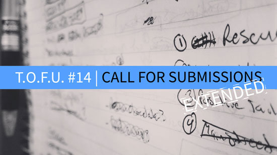 Image contains a notepad with illegible text in black ink and a pen on the left-hand side. In the foreground, there is text in the middle of the screen on a strip of blue that says "T.O.F.U. #14 |" in white and "Call For Submissions" in black. Below the word "submissions", the word "Extended" is in white.