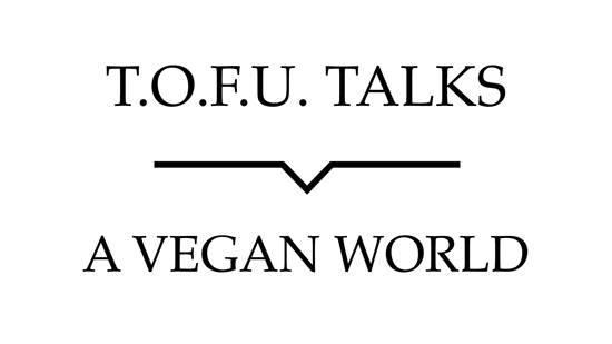 Image contains a white background with black text that says "T.O.F.U. Talks" above a black line with a small indent in the centre pointing below to text that says "A Vegan World".