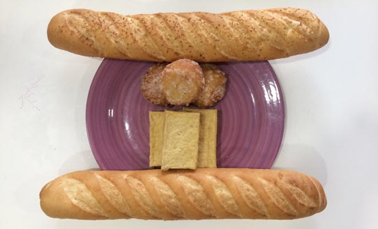 Image contains a photo of a purple plate with blocks of tofu and sugared balls on it. On opposite sides of the plate, there are two baguettes.