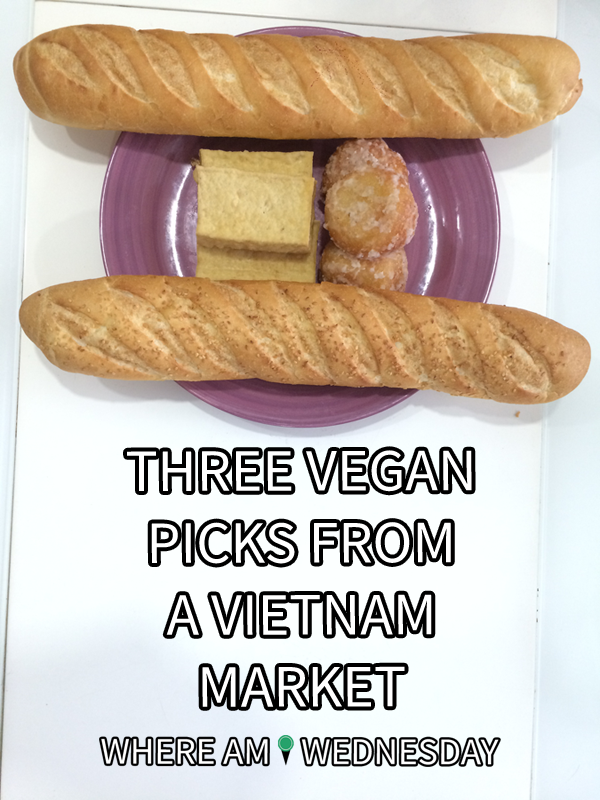 Image contains a photo of a purple plate with blocks of tofu and sugared balls on it. On the top and bottom of the plate, there are two baguettes. Below the plate, there is white text that says "Three Vegan Picks From A Vietnam Market" and "Where Am I Wednesday".
