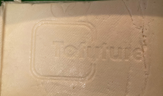 Tofuture logo stamped into tofu after pressing.